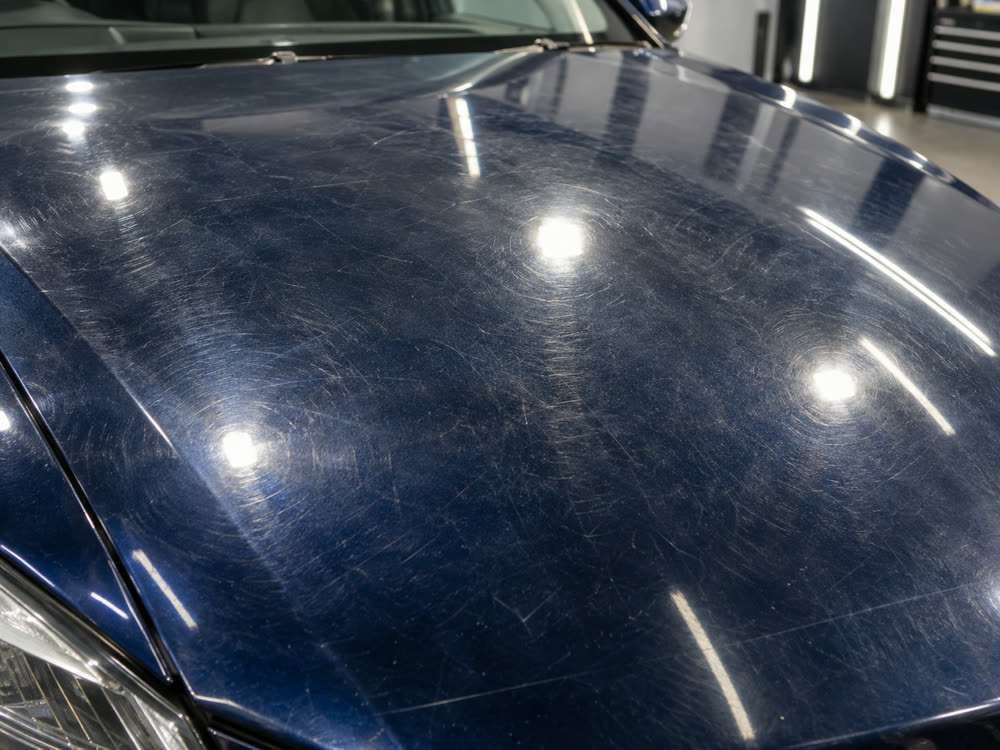 The same bonnet before: swirl marks and fine scratches all over the paint